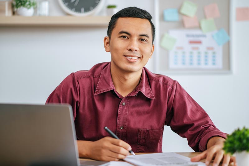 man working office with papers laptop desk
